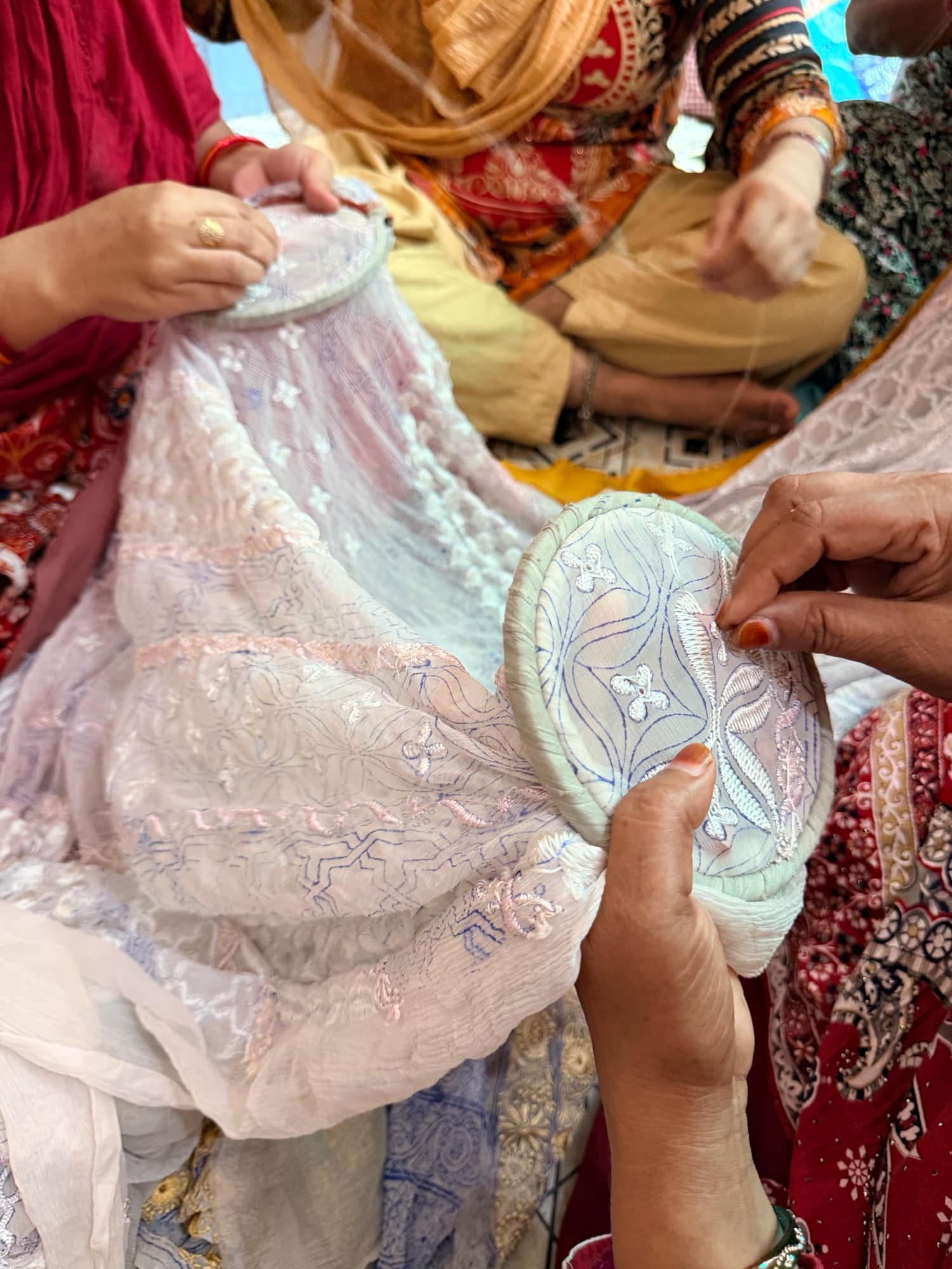 Women artisans embroidering together on a shared frame