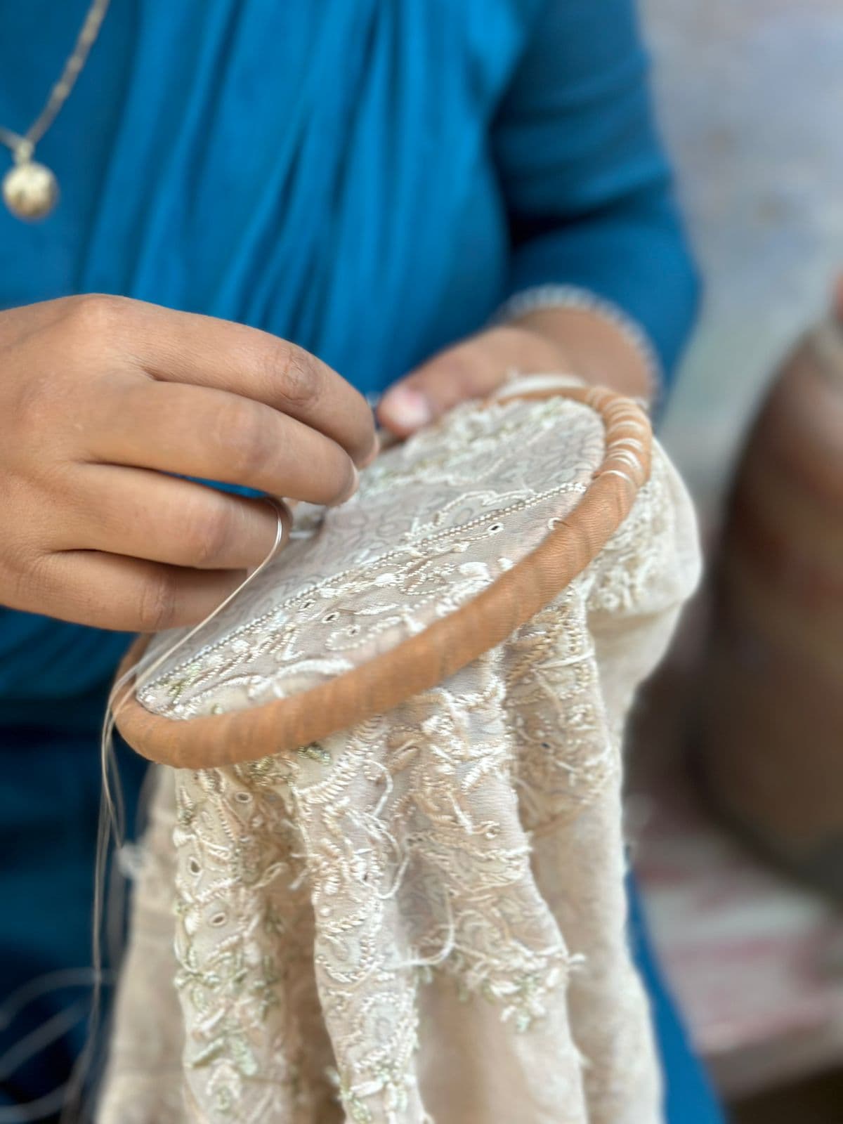 Artisan embroidering chikankari by hand on a frame
